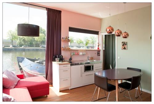 阿姆斯特丹Private guesthouse BnB The Waterhouse houseboat的一间带桌子的客厅和一间带船的厨房
