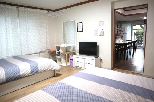 首尔郑家旅馆的一间卧室配有两张床和一台平面电视