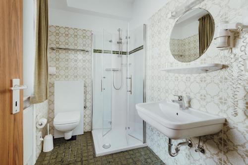 奥斯纳布吕克克鲁特酒店的一间带水槽、淋浴和卫生间的浴室