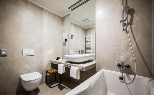 奥帕提亚Boutique & Design Hotel Navis的一间带水槽、浴缸和卫生间的浴室
