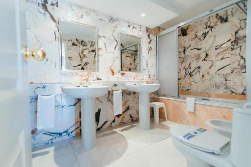 洛斯克里斯蒂亚诺斯Hollywood Mirage - Excel Hotels & Resorts的一间带两个盥洗盆和卫生间的浴室
