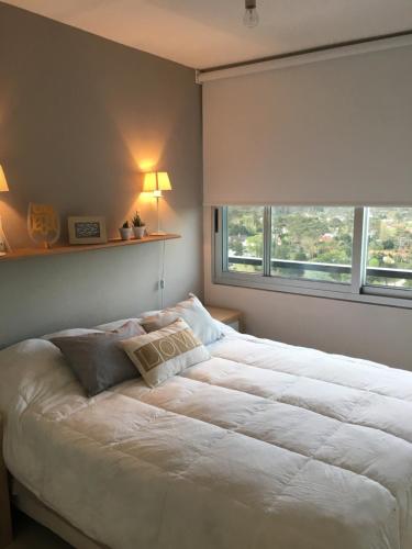 埃斯特角城Edificio Jardines del Country Piso 19的卧室配有一张大白色床和窗户