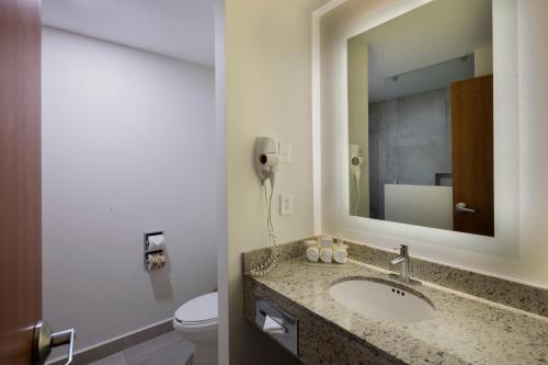 普埃布拉普埃布拉智选假日酒店的一间带水槽和卫生间的浴室以及一部电话