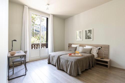 巴塞罗那阿斯帕奇亚斯兰布拉加泰罗尼亚套房公寓的一间卧室配有一张床,上面有水果盘