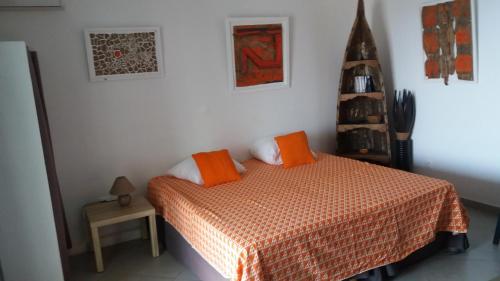 豪特尔STUDIO LE PHARE的一间卧室配有带橙色枕头的床