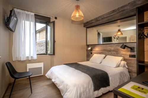 Le BleymardLogis Hôtel restaurant La Remise的一间卧室配有一张床、一把椅子和镜子