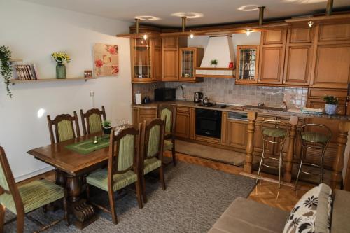 贾科沃Apartman Kaya的厨房配有木制橱柜和桌椅