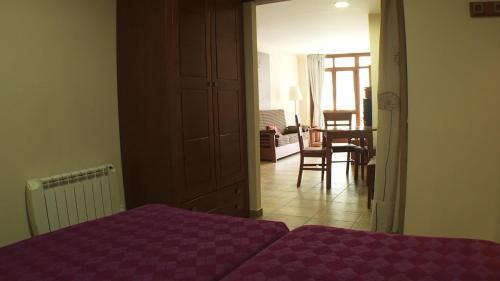 博西安缇福尔公寓的一间带紫色床的卧室和一间餐厅
