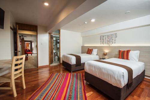 库斯科Casa Matara Boutique的酒店客房带两张床和一个客厅