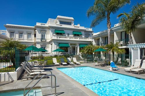 圣地亚哥格罗利埃塔湾旅馆的一座带游泳池和棕榈树的大型白色豪宅