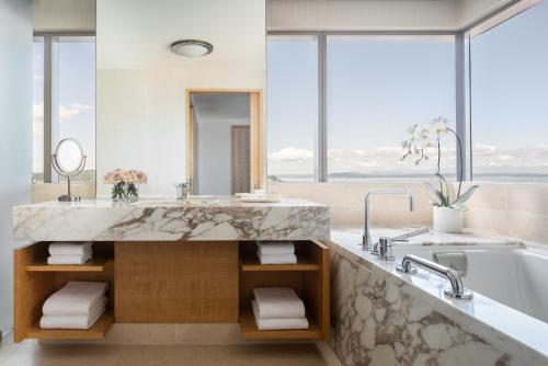 西雅图四季酒店西雅图的浴室配有大型大理石盥洗盆和浴缸。