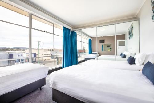 Derwent Park卡莱尔睡帽酒店的配有大窗户的酒店客房内的两张床