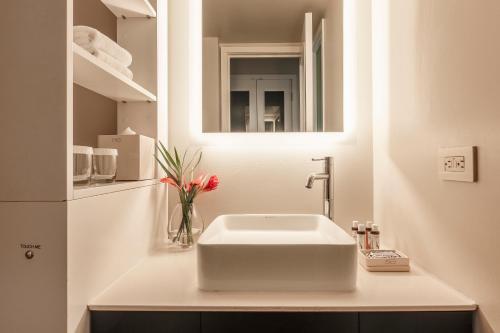 檀香山Hotel Renew的浴室设有白色水槽和镜子