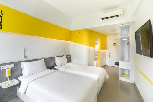 雅加达芒加莱耶洛酒店的黄色和白色的客房内的两张床