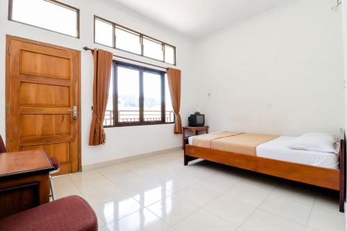 卡里乌昂Hotel Wismancala Kaliurang的一间卧室设有一张床和一个窗口