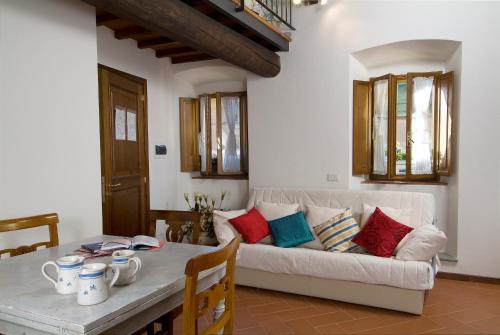 普拉托阿可德米雅公寓酒店的客厅配有白色的沙发和桌子