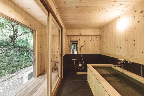 KosugeNIPPONIA Kosuge Village的木制浴室设有浴缸和窗户。