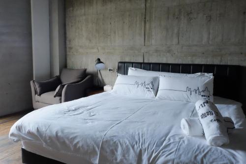 台东CoffeeLoft 咖啡工寓的卧室配有白色的床和椅子