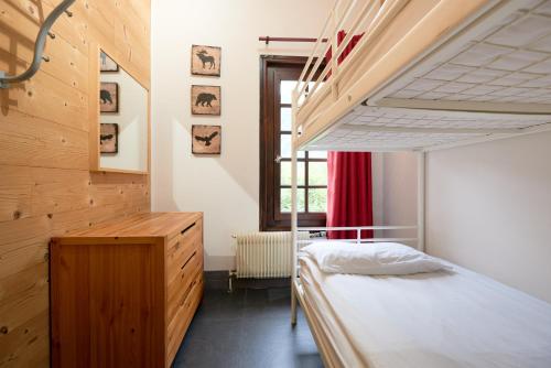 夏蒙尼-勃朗峰夏蒙尼旅馆的一间卧室配有双层床和窗户。