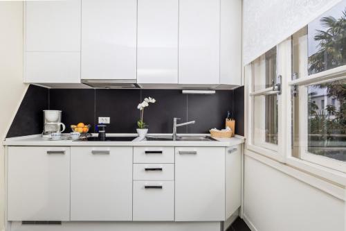 奥帕提亚罗纳奥帕蒂亚高级公寓的白色的厨房设有水槽和窗户