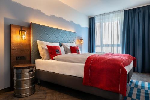 汉堡Holiday Inn - the niu, Keg Hamburg Ost, an IHG Hotel的酒店客房配有一张带红色枕头的大床