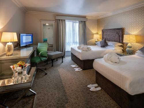 香侬翠斯橡木酒店的酒店客房配有两张床和一张书桌