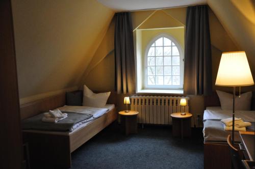 莱宁Zentrum Kloster Lehnin的小房间设有两张床和窗户
