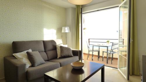 卡莱塔德贝莱斯Maravilloso apartamento en primera linea de playa con vistas al mar en Caleta de Vélez 2 C的客厅配有沙发和桌子