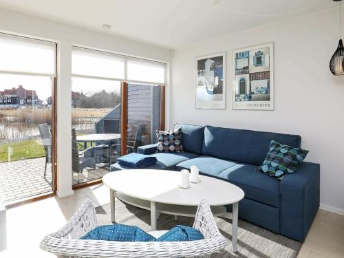 博恩瑟4 person holiday home in Bogense的客厅配有蓝色的沙发和桌子