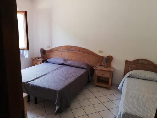马尔恰纳Il Castagno的一间卧室设有两张床和两个床头柜