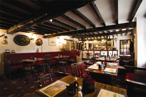 Branston敦斯顿红狮子宾馆的一间带桌椅的餐厅和一间酒吧