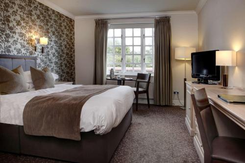 切姆Ivy Hill Hotel, Sure Hotel Collection by Best Western的酒店客房设有一张大床和一张书桌。