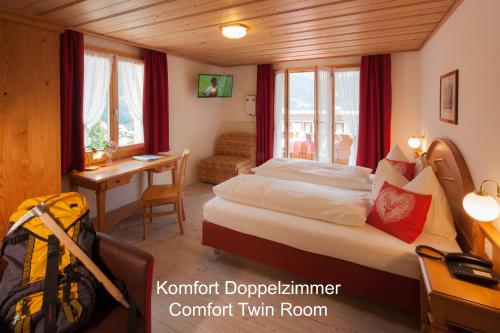 格林德尔瓦尔德海尔森酒店 - 格林德瓦的一间卧室配有一张床和一张书桌
