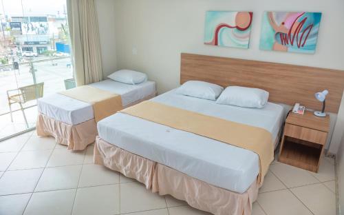 泰谢拉迪弗雷塔斯Hotel QualitySul的酒店客房设有两张床和窗户。