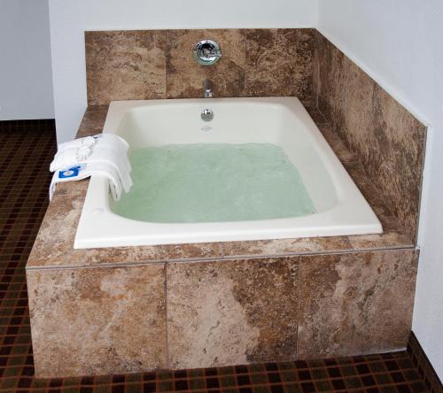 格林维尔快捷套房酒店的浴室内配有水浴缸