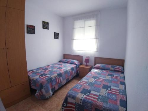 奥罗佩萨德尔马Galicia Vidaber Primera Línea的一间卧室设有两张床和窗户。