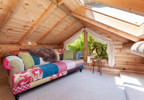 曼海德Porthole Log Cabin的木制阁楼内配有沙发的房间