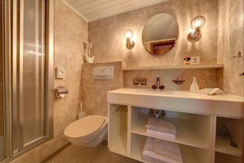 韦斯巴德瓦尔德盖斯特豪斯乐蒙酒店的一间带水槽、卫生间和镜子的浴室