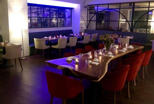 杜伊斯堡拉莫尔盖尔尼酒店的一间带长桌和红色椅子的用餐室