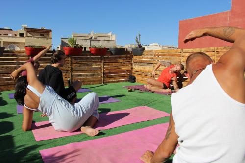 塔姆拉赫特乌兹达尔Sunset Surfhouse Morocco的一群人在瑜伽垫上做瑜伽