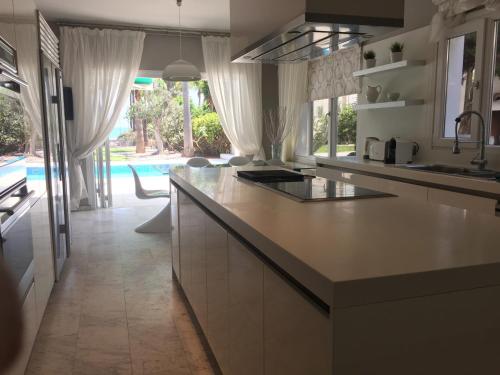 皮尔瓦利亚Deluxe First Line Villa的厨房配有柜台和游泳池。
