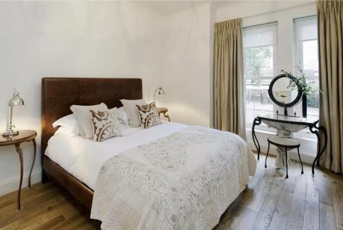 伦敦欧罗巴大楼公寓的一间卧室配有一张床、一张桌子和一个窗户。