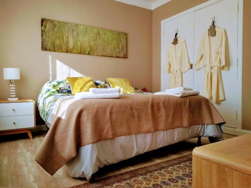 圣卡洛斯-德巴里洛切Vintage Bariloche Hostel Boutique的卧室配有挂在墙上的挂有衣服的床