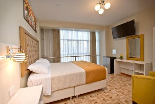 塔克纳Mercé Hotel的酒店客房,配有床和电视