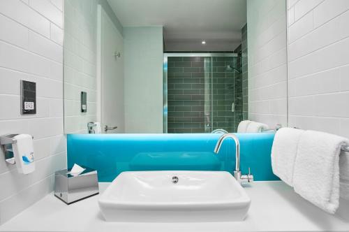 伦敦德里Holiday Inn Express - Derry - Londonderry, an IHG Hotel的白色和蓝色的浴室设有水槽和淋浴