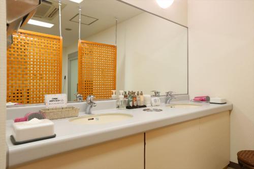 札幌札幌法华俱乐部酒店的一间带两个盥洗盆和大镜子的浴室