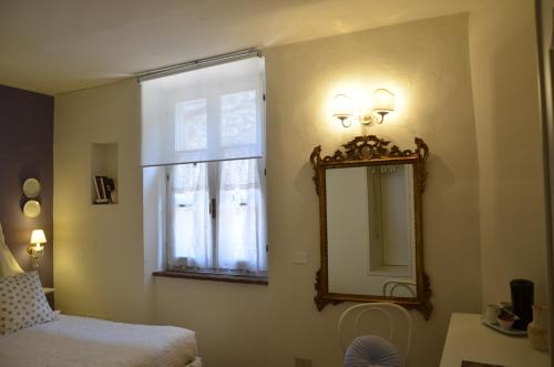 圣吉米纳诺安娜尼多二号招待所的一间卧室配有镜子、一张床和一个窗户