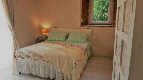 坎丕里亚麦利蒂玛Amore a prima vista b&b的一间卧室配有一张带绿色枕头的床和一扇窗户