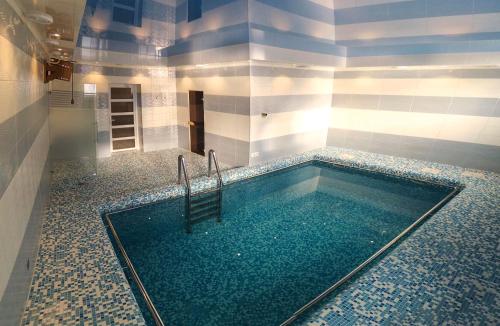 捷尔诺波尔阿瓦隆宫酒店的浴室内带椅子的游泳池