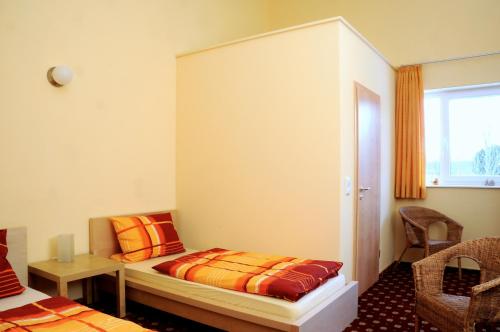Schemmerhofen楚格恩楚格酒店的一间卧室配有一张床、一张书桌和一个窗户。
